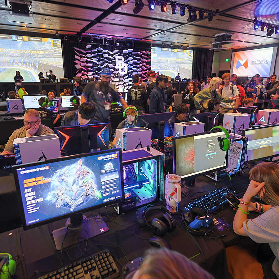 A group of gamers in large room with lots of screens and displays