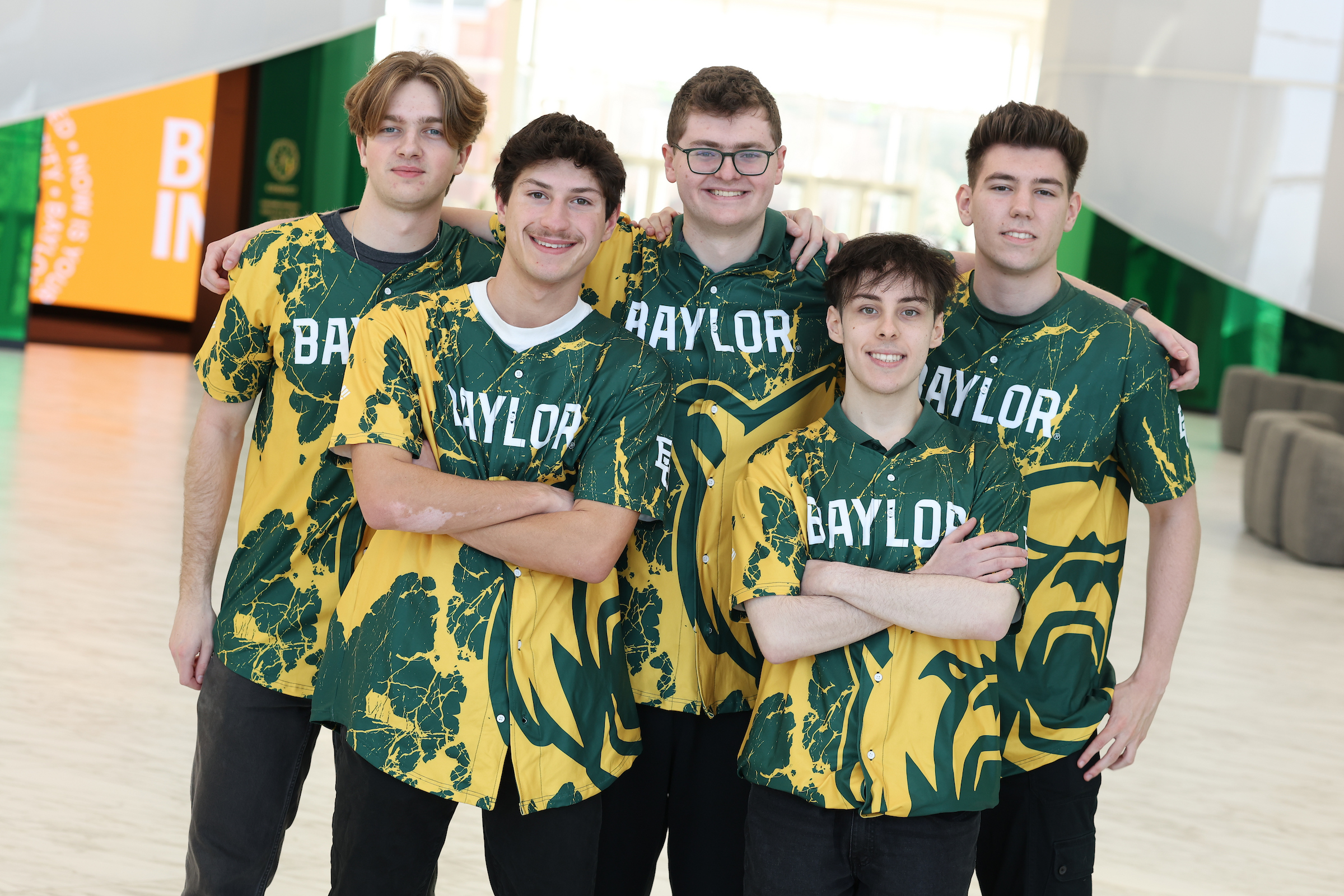 Team photo of the Baylor esports varsity Rocket League roster standing together in matching green and gold jerseys